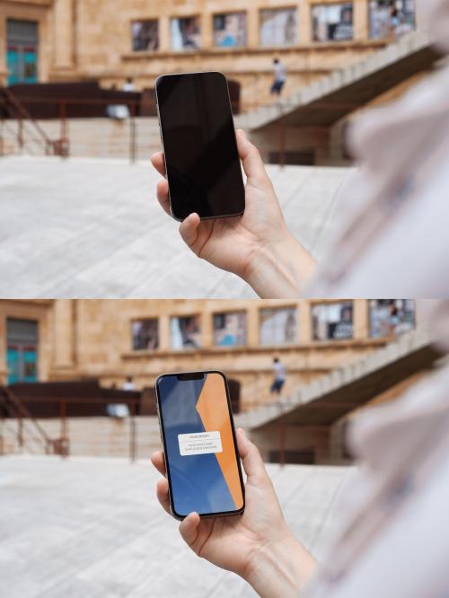 Mockup of person holding mobile phone with customizable screen in a city 649152370