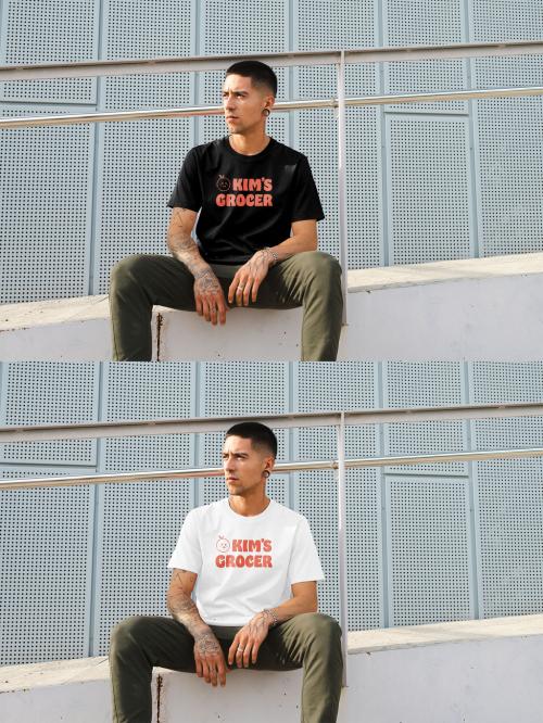 Mockup of man wearing t-shirt with customizable color sitting by building, front view 644104799