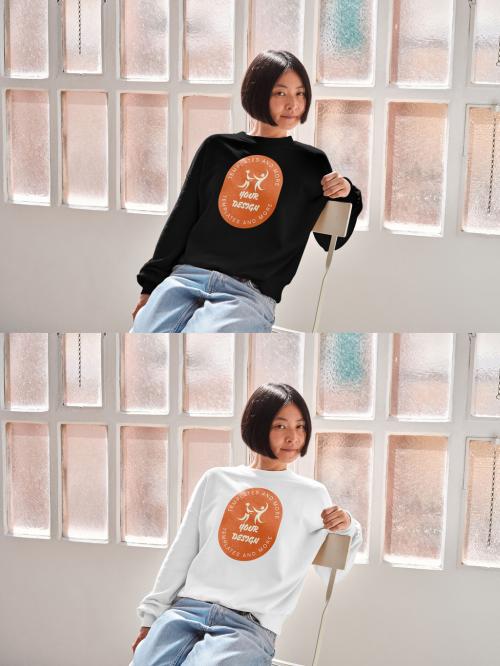Mockup of Asian woman wearing sweatshirt with customizable color on chair by window 644103610