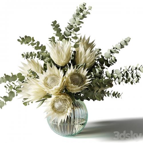 Bouquet with white proteas and eucalyptus in a ribbed glass vase