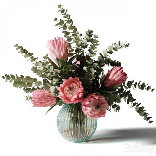 Bouquet with pink proteas and eucalyptus in a ribbed glass vase