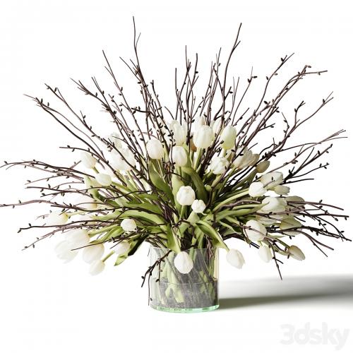 Bouquet of white tulips and branches in a glass vase