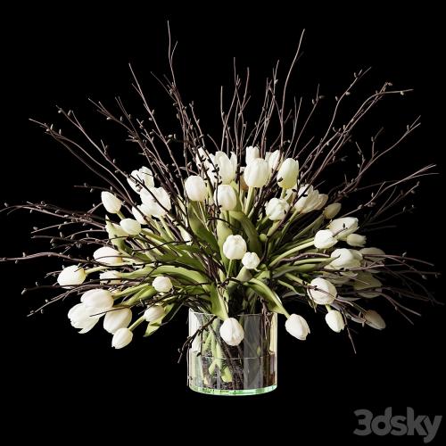 Bouquet of white tulips and branches in a glass vase