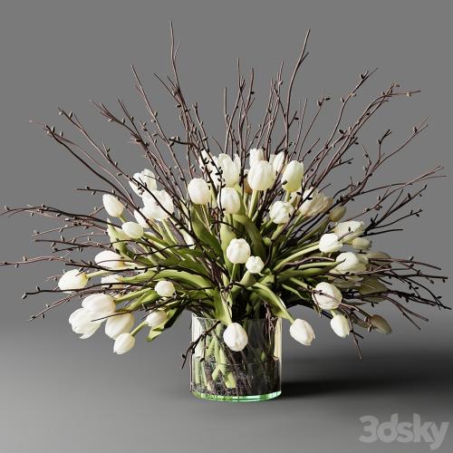 Bouquet of white tulips and branches in a glass vase