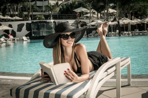 Deeezy - Smiling woman with book on poolside - 5 Stock Photos