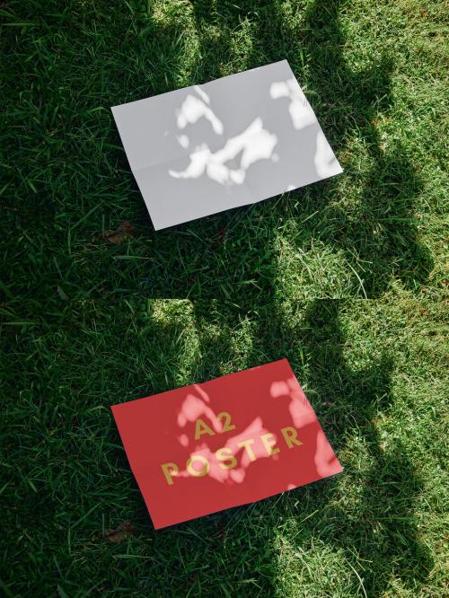 Horizontal A2 Poster Mockup Over Green Grass With Sunlight Shadows