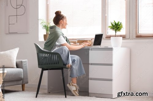 Young Woman Sitting At Workplace And Working With Laptop In Living Room 6xJPEG