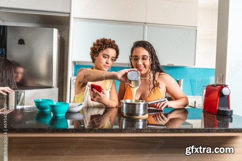 Young Women In The Kitchen Eating Tapioca Dice, A Traditional Snack From Brazil 5xJPEG