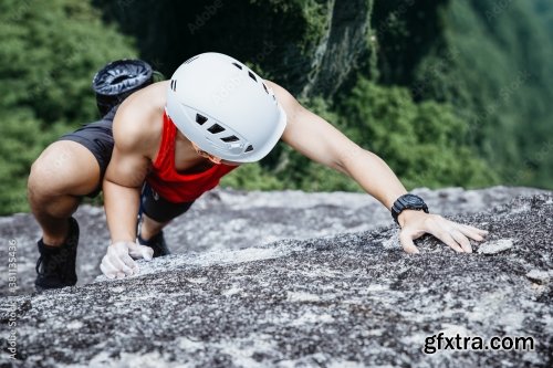 Asian Man Rock Climber In Black Pants Climbing On The Cliff 6xJPEG