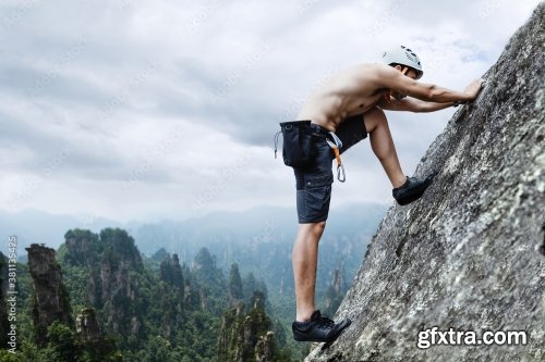 Asian Man Rock Climber In Black Pants Climbing On The Cliff 6xJPEG